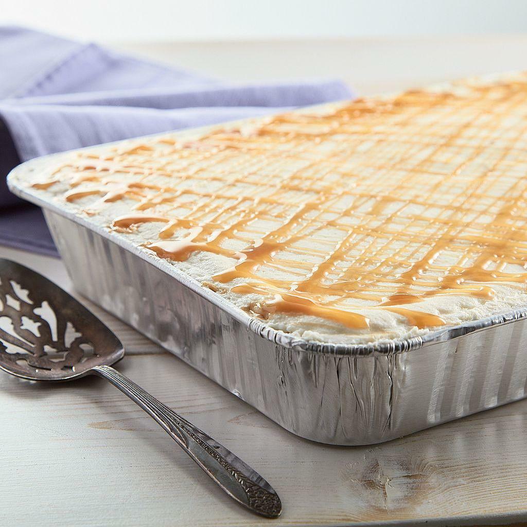 A 13x9 pan of tres leches cake drizzled with caramel